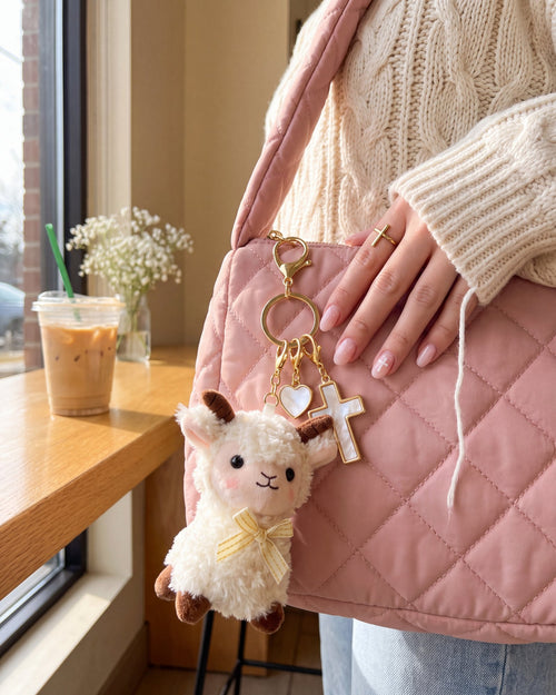 The Little Flock Set of four faith charms clipped on a blush pink quilted bag